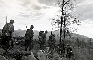 Soldaten der Wehrmacht marschieren durchs Gelände 
