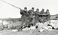 Fünf Soldaten der Wehrmacht ziehen an einer Kette um einen Baum umzulegen 
