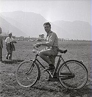 Ein Herr auf einem Fahrrad auf dem Flugplatz. 
