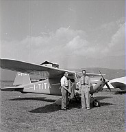 Zwei Männer stehen vor einer kleinen Flugmaschine während eines Flugwettkampfes für Amateure. 