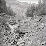 Bauarbeiten zur Errichtung des Wasserkraftwerks (Baufirma Collini): Bachverbauung, ein Bach und Staumauern aus Stein. 