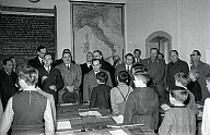 Carlo Vischia, Oscar Benussi und eine Gruppe Herren besuchen eine deutsche Jungenklasse während einer Unterrichtsstunde 