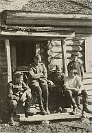 Quattro soldati della Wehrmacht ed un uomo davanti ad una baracca del servizio informazioni